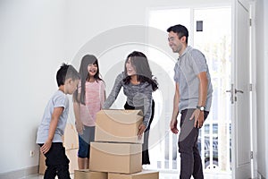 Parent and kids with cardboard box. moving to new house