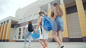 Parent leads to school child with backpack back view. Kids go to school with backpacks education concept. Mom leads