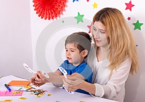 Parent learning and playing with kids. Mother or teacher painting or learning english letters with children.Homeschooling