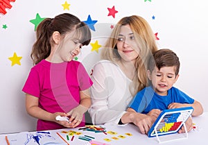 Parent learning and playing with kids. Mother or teacher painting or learning english letters with children.Homeschooling