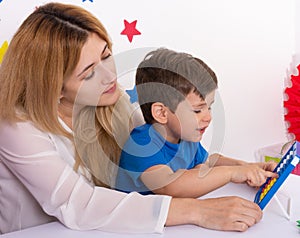 Parent learning and playing with kids. Mother or teacher painting or learning english letters with children.Homeschooling