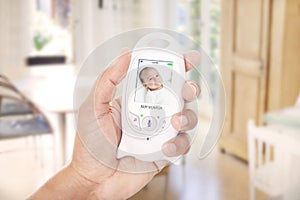 Parent monitoring baby through baby monitor