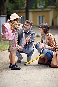 Parent and pupil girl are going to school