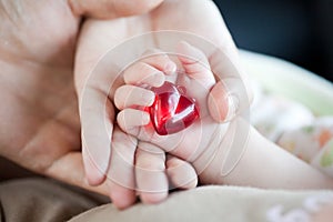 Parent's and baby's hands with heart