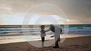 Parent scolding little boy on beach. Young mother talking boy resting shore