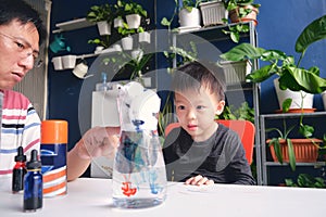 Parent sitting homeschooling with little kid, Father and son having fun making easy science experiment, Kid-friendly easy science