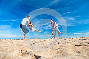 Parent Swinging Children at the Beach