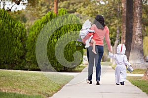 Parent Taking Children Trick Or Treating At Halloween