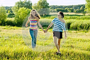 Parent and teenager, Happy mother and teen daughter 13, 14 years old hold hands go laugh talk.