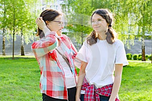 Parent and teenager, mother talks with her teen daughter 13, 14 years old. Background nature, park photo