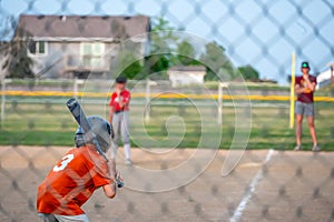 Parent view behind a chain link fence and home plate with a batter ready
