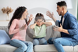 Parental Conflicts. Upset Little Girl Covering Ears Not To Listen Parents Arguing