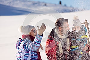 Parenthood, fashion, season and people concept - happy family with child on sled walking in winter outdoors