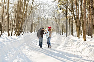 Parenthood, season and people concept - happy family with child in winter clothes outdoors