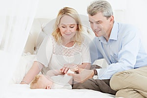 Parenting family. Mother and father playing with little newborn baby