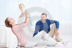 Parenting family. Mother and father playing with little newborn baby