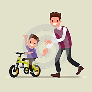 Parenting. The father teaches his son to ride a bicycle. The fir