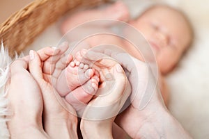 Parenting hands holding small baby's feet