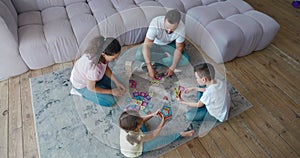 Parenting and happy childhood concept. Indoor entertainment with children. Parents playing board games and a magnetic