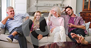 Parents With Adult Offspring Watching Television At Home