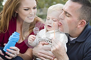 Parents Blowing Bubbles with Child Boy in Park