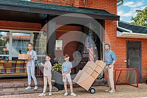 parents with cardboard boxes and children