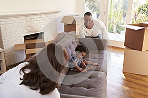 Parents Carry Son On Sofa Into New Home On Moving Day