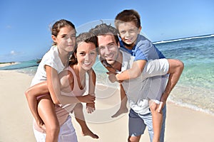 Parents carrying children on their back on the beach