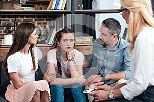 parents cheering up daughter on therapy session by female counselor