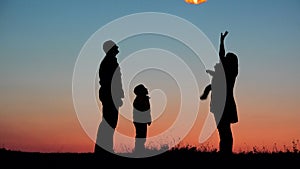 Parents, child and baby silhouette rising lightning sky lantern, release hope