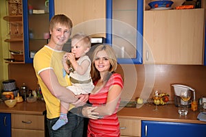 Parents and child on hands in kitchen 2