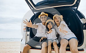 Parents and children daughter enjoying road trip sitting on family back car motion wave to camera