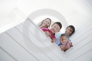 Parents With Children Looking Over White Wall