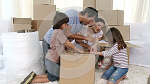 Parents and children moving house packing boxes