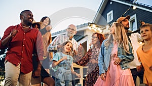 Parents, Children and Multicultural Friends Dancing Together at a Garden Party Disco Event at Home