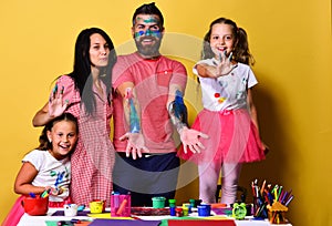 Parents and children painted all over with gouache on yellow