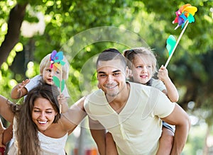 Parents with children playing colorful windmills