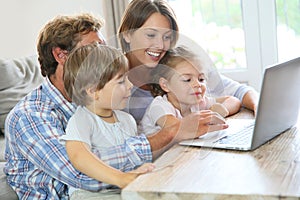 Parents with children playing on laptop