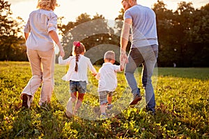 Parents with children walking in nature, back view photo