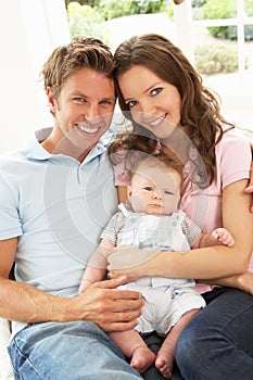 Parents Cuddling Newborn Baby Boy At Home photo