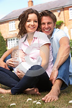 Parents Cuddling Newborn Baby Boy Outdoors At Home