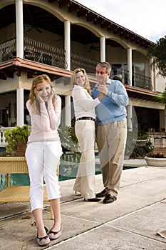 Parents dancing behind amused teen daughter photo