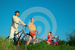 Parents with daughter on bicycles in evening