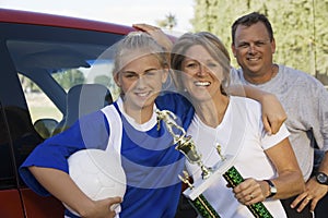 Parents With Daughter Holding Soccer Trophy