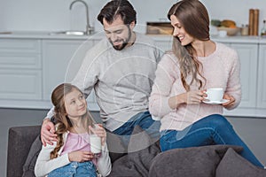 parents and daughter with milk and coffee