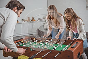 parents and daughter playing table football