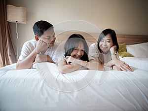 Parents and daughter reclined comfortably on a soft bed. in the hotel. Family vacation on vacation