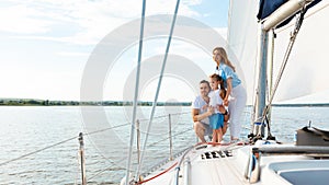 Parents And Daughter Standing On Yacht Deck On Summer Day