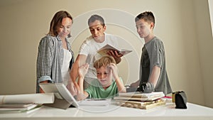Parents doing homework with kids. Father and mother, and brother helping son do homework