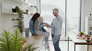 Parents entertaining child with hand stacking game indoors